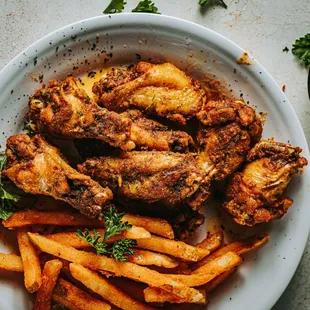 a plate of chicken wings and french fries