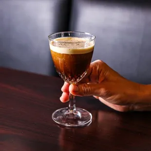 a person holding a glass of coffee