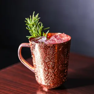 a copper mug with a sprig of rosemary