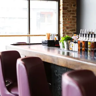 a row of purple chairs at a bar