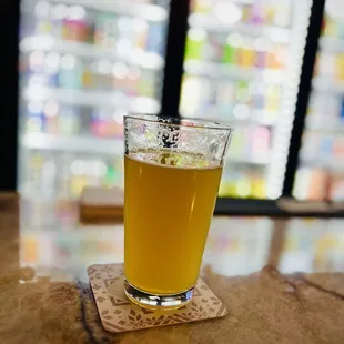 a glass of beer on a coaster