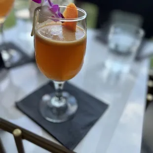 a glass of orange juice on a table