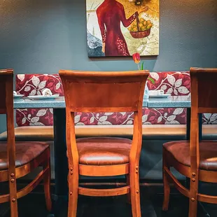 a table and chairs with a painting on the wall