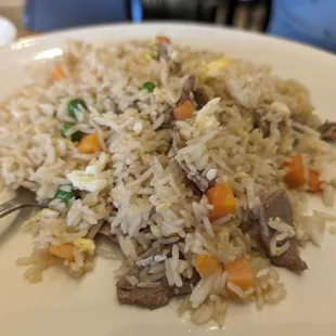 a plate of rice with meat and vegetables