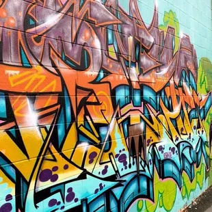 a man walking past a graffiti covered wall