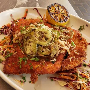 Chicken schnitzel topped with crispy shallots and jalapeno, cabbage, jicama &amp; red pepper slaw with agave dijon, grilled lemon