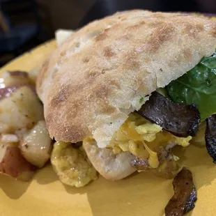 a breakfast sandwich on a yellow plate