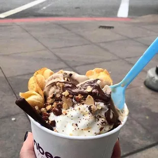 a hand holding a cup of ice cream