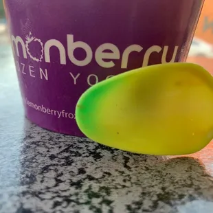 a yellow spoon next to a purple cup