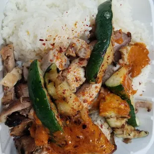 Grilled chicken plate with peanut sauce, rice and zucchini.