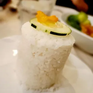 a plate of rice with a cucumber on top