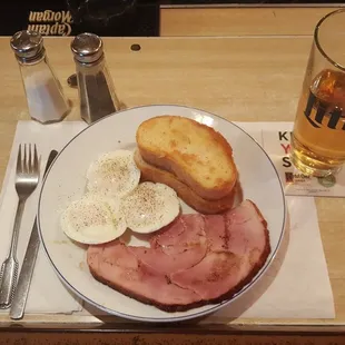 a plate of ham, eggs, and toast