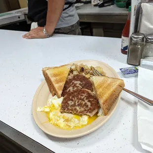2 eggs over medium, sausage patties, hash browns, toast &amp; coffee. Not pictured: hot sausage Po Boy taken away for lunch.