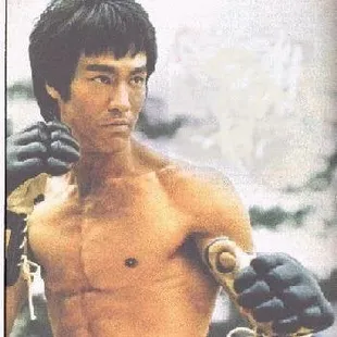 a shirtless man holding a pair of gloves