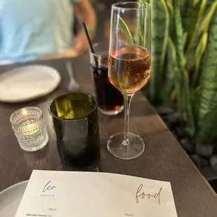 a glass of wine and a menu on a table