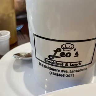 Leo&apos;s coffee mug showing logo address and phone info.