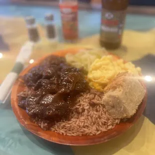 Oxtails with sides of rice, cabbage, Mac and cheese, and cornbread.