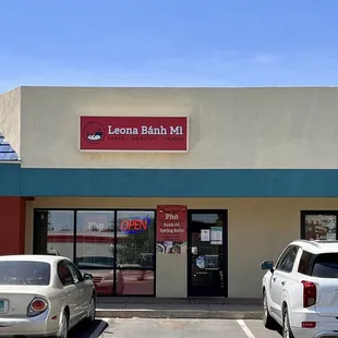 two cars parked in front of a business