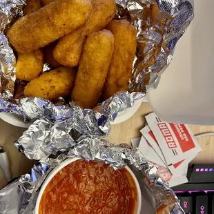 a bowl of sauce and a bowl of fried tater tots