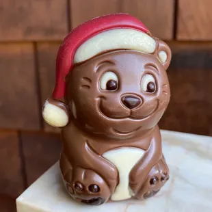a chocolate bear wearing a santa hat