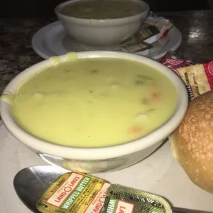 a bowl of soup and a roll