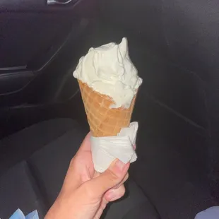 a hand holding an ice cream cone
