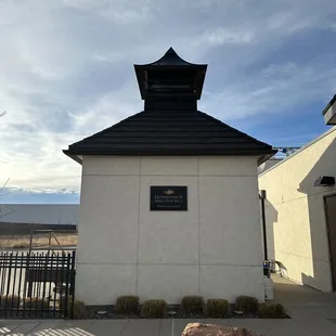 a small white building with a black roof