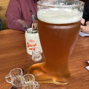 a woman sitting at a table with a glass of beer
