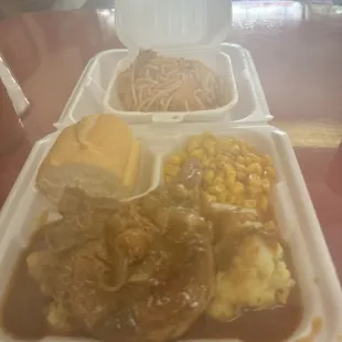 Smothered pork chops, mashed potatoes, French bread, baked spaghetti.