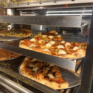 Many types of pizza by the slice or by the pie