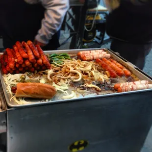 a variety of hot dogs on a grill