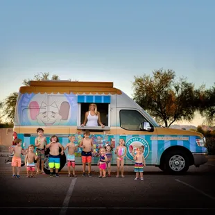 a group of children standing in front of a ice cream truck