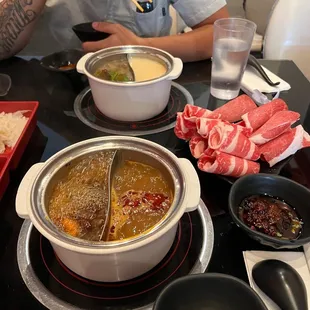 a man sitting at a table with bowls of food