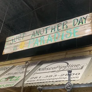 a sign for another day paradise