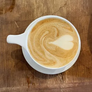 a cup of coffee on a wooden table