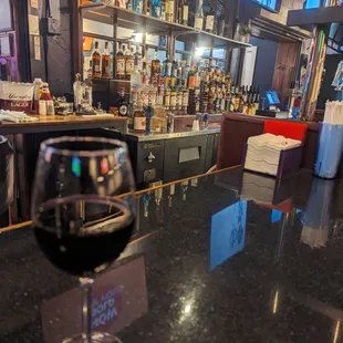 a glass of wine on a bar