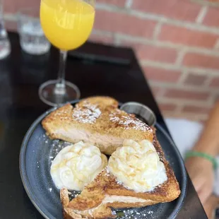 a plate of french toast and a glass of orange juice