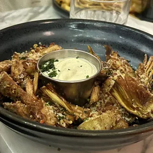 a bowl of fried artichokes and a bowl of dip