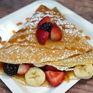 a crepe with fruit and powdered sugar
