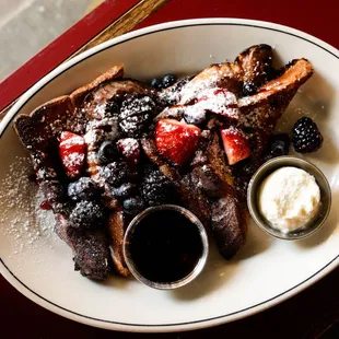Pain Perdu French toast w/fresh berries, raspberry coulis, maple syrup + cream cheese icing