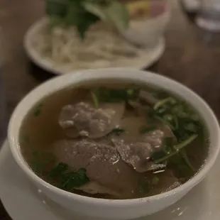 a bowl of soup and a plate of noodles