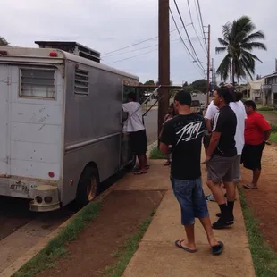 a group of people standing outside of a truck
