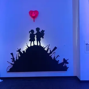 a silhouette of a couple on a hill with a heart shaped balloon