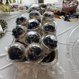 Yogurt parfaits topped with granola &amp; honey in bin with ice.