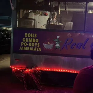 a man sitting in front of a food truck