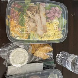 Chef&apos;s salad with creamy cilantro dressing, croutons and a water. Taco wrap with ranch dressing, tortilla chips, and a water.