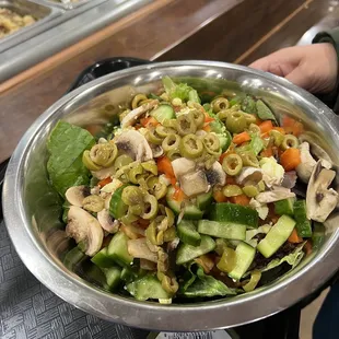 a person holding a bowl of salad