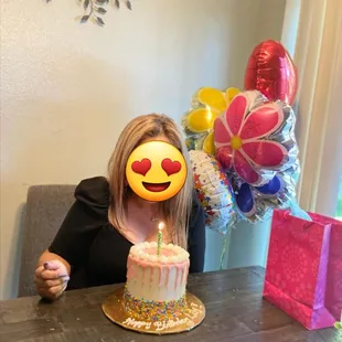 a woman blowing out a candle on a birthday cake