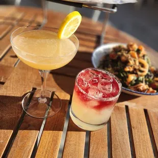 a pizza and two cocktails on a table