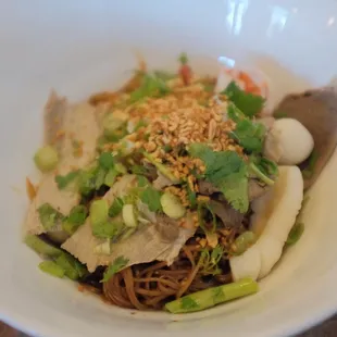 a bowl of noodles with meat and vegetables